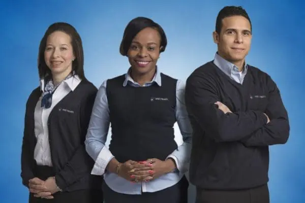 Three VNS Health team members standing together and smiling.