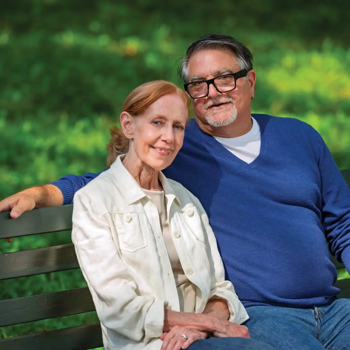 Older couple sitting on a bench outside