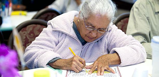 An elderly woman writing 