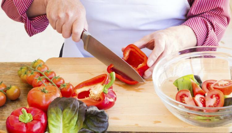 Cocinero rebanando pimientos.