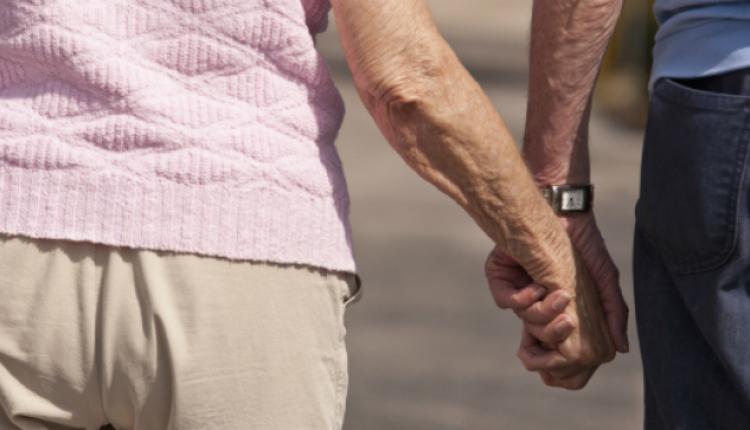 An elderly couple holding hands