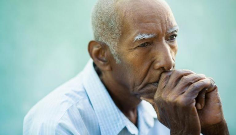 Hombre mayor con una mirada triste y pensativa.