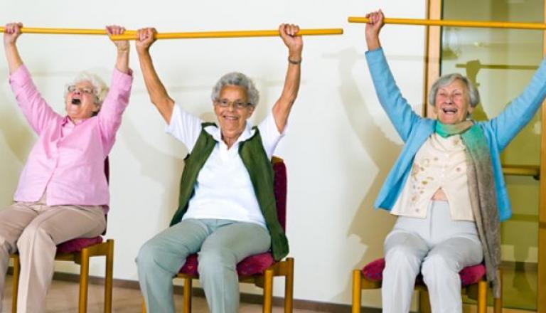 Three women doing chair exercises.