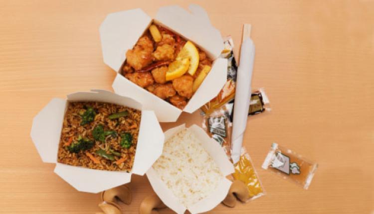 Cajas de comida china abiertas sobre la mesa.