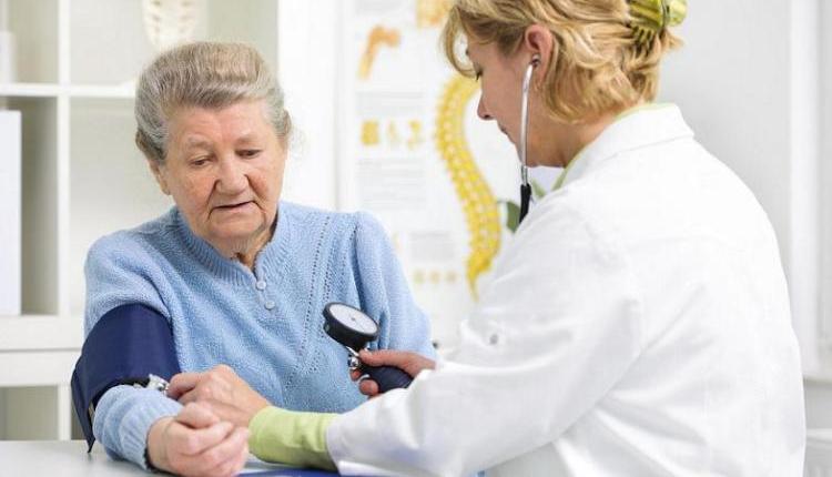 Médica midiendo la presión arterial a una mujer.