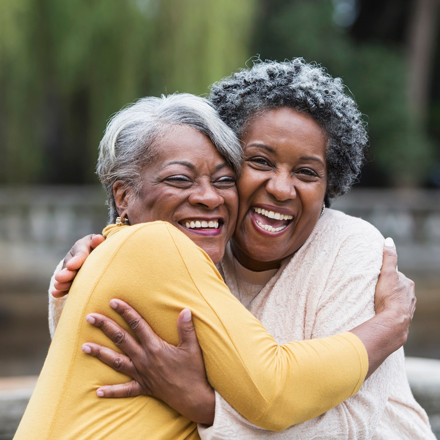 Two senior women friends hugging